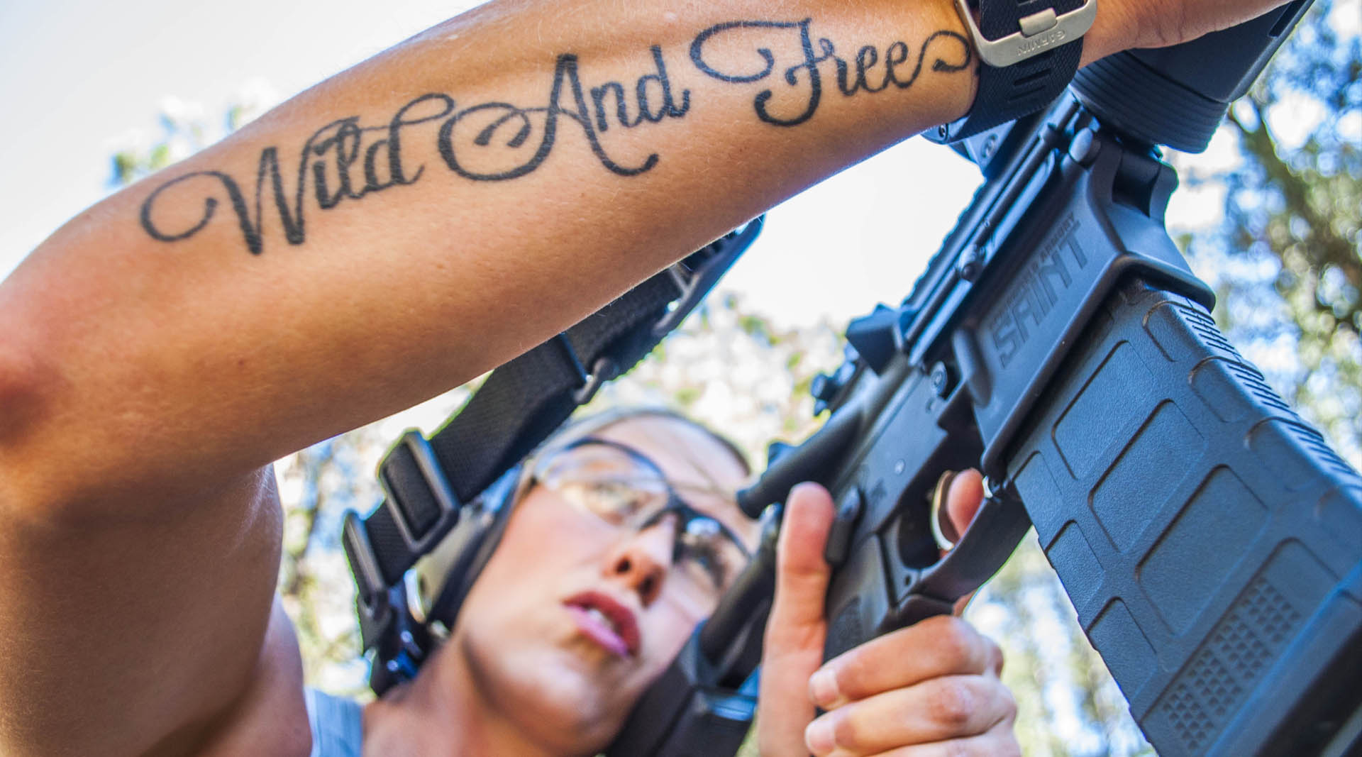 Holly Wild Yolo Freeman manipulating her Springfiled Armory AR showing a cool tattoo Wild and Free